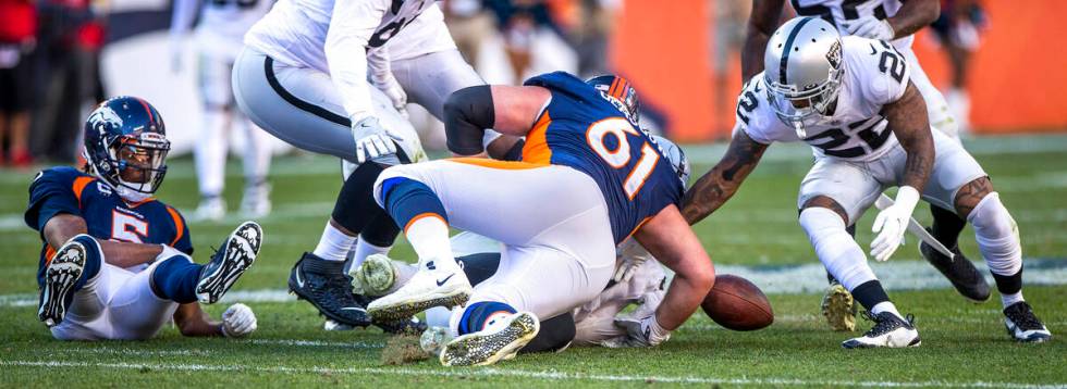 Raiders' defensive back Keisean Nixon (22, right) eyes a fumble by Denver Broncos quarterback T ...