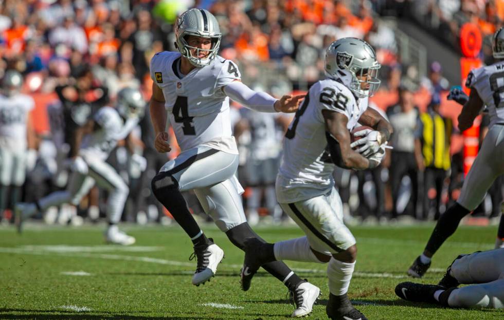 Raiders quarterback Derek Carr (4) hands the football off to Raiders running back Josh Jacobs ( ...