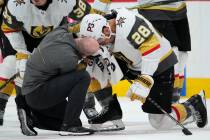 Vegas Golden Knights left wing William Carrier (28) is looked at by a trainer after taking a sk ...