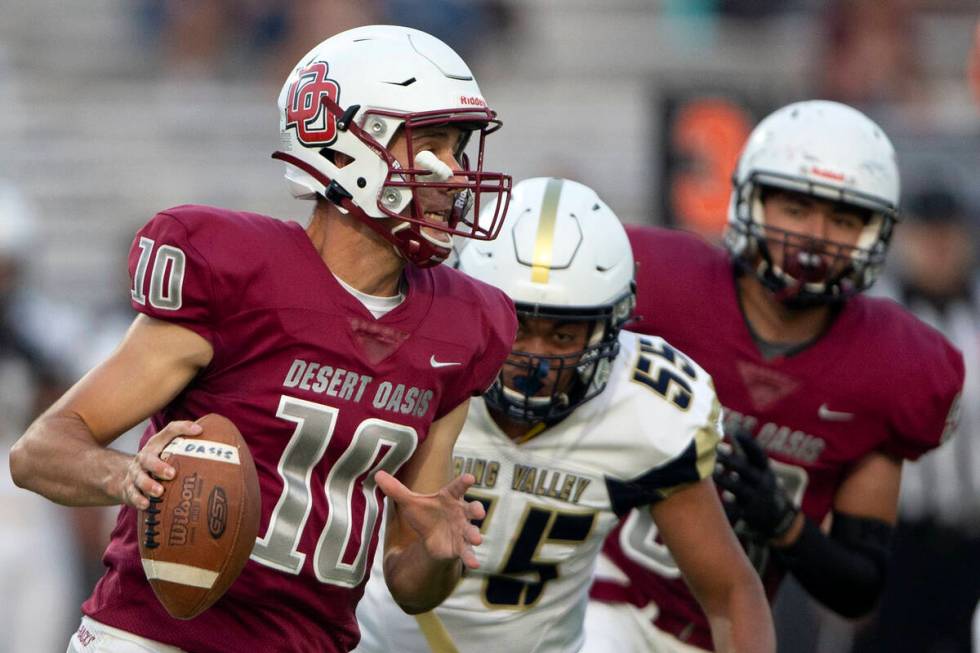 Desert Oasis quarterback Tyler Stott (10) looks to pass while Spring Valley offensive lineman T ...