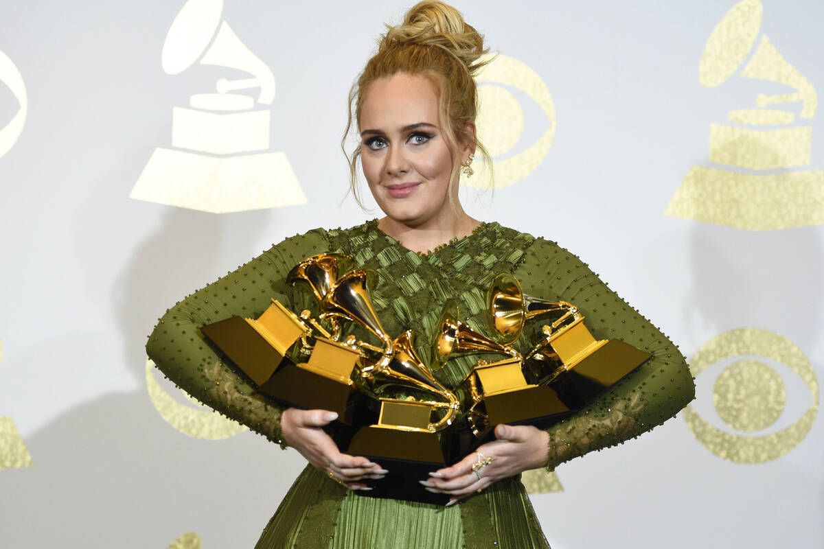 Adele poses with the awards for album of the year and best pop vocal album for "25" and song of ...
