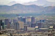 In this Tuesday, July 24, 2018 photo, a jet comes in for approach over downtown Phoenix. (AP Ph ...