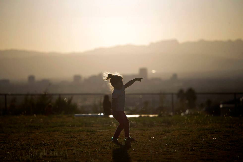 Cali Ortiz, 3, plays behind field where Green Valley and Sunrise Mountain play a boys high scho ...