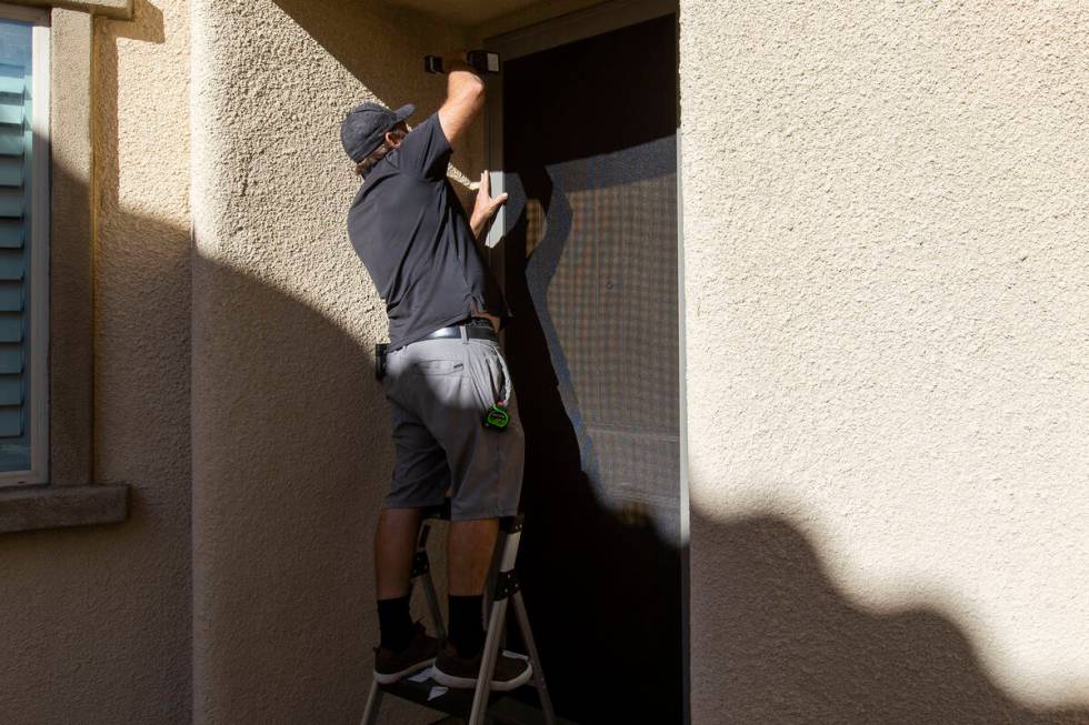 Technician Jed Roehm installs a MeshTec door at a client's home in Sun City Summerlin on Saturd ...