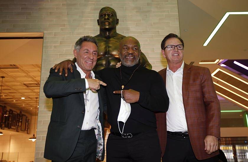Former boxer Mike Tyson, center, poses for photos with Mulberry Street Pizzeria founder and own ...