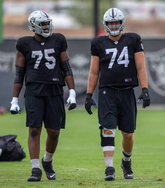 Raiders offensive tackles Brandon Parker (75) and Kolton Miller (74) interact during a practice ...