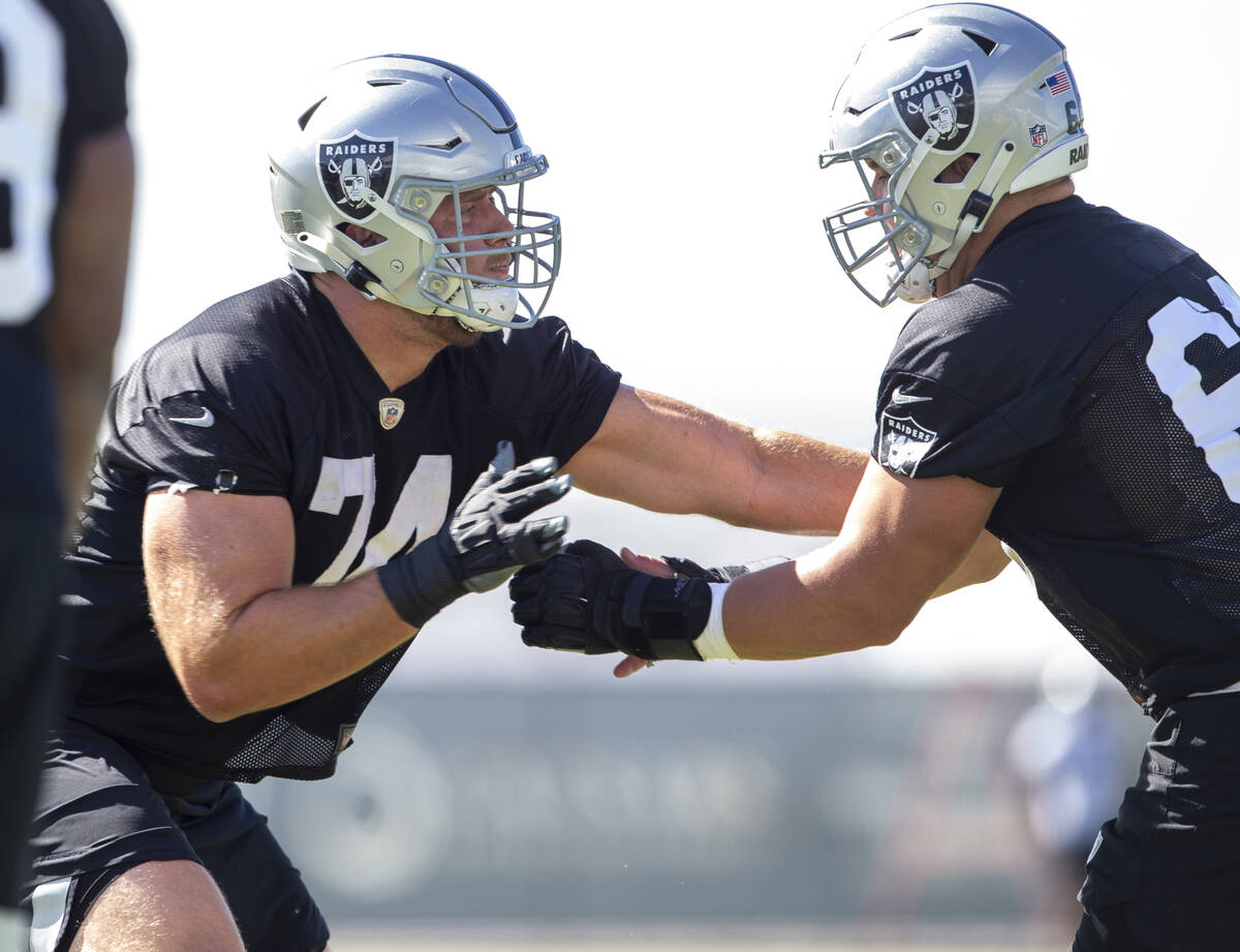 Raiders offensive tackle Kolton Miller (74) pushes off against Raiders center Nick Martin (66) ...