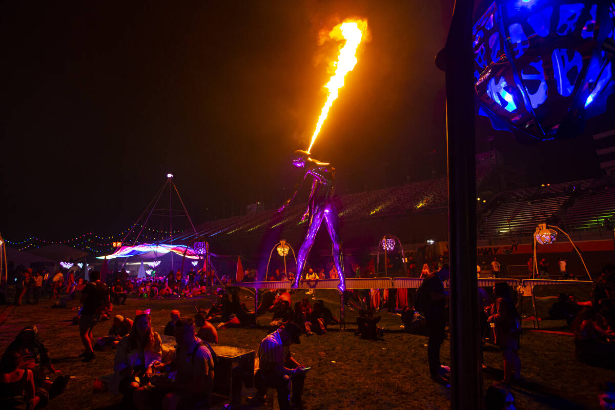 Attendees hang out around a pyrotechnic sculpture during the Electric Daisy Carnival at the Las ...