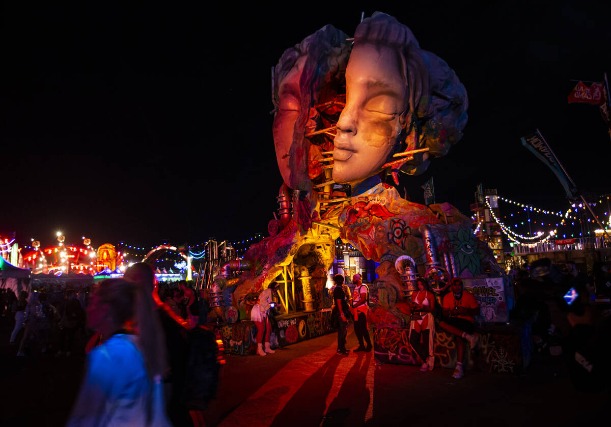 Attendees walk by an art installation during the second day of the Electric Daisy Carnival at t ...