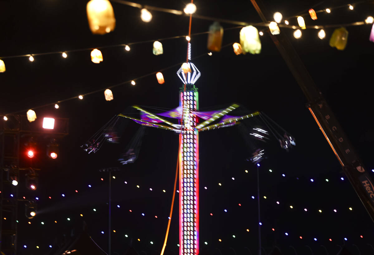 A carnival ride is pictured through various lights during the second day of the Electric Daisy ...