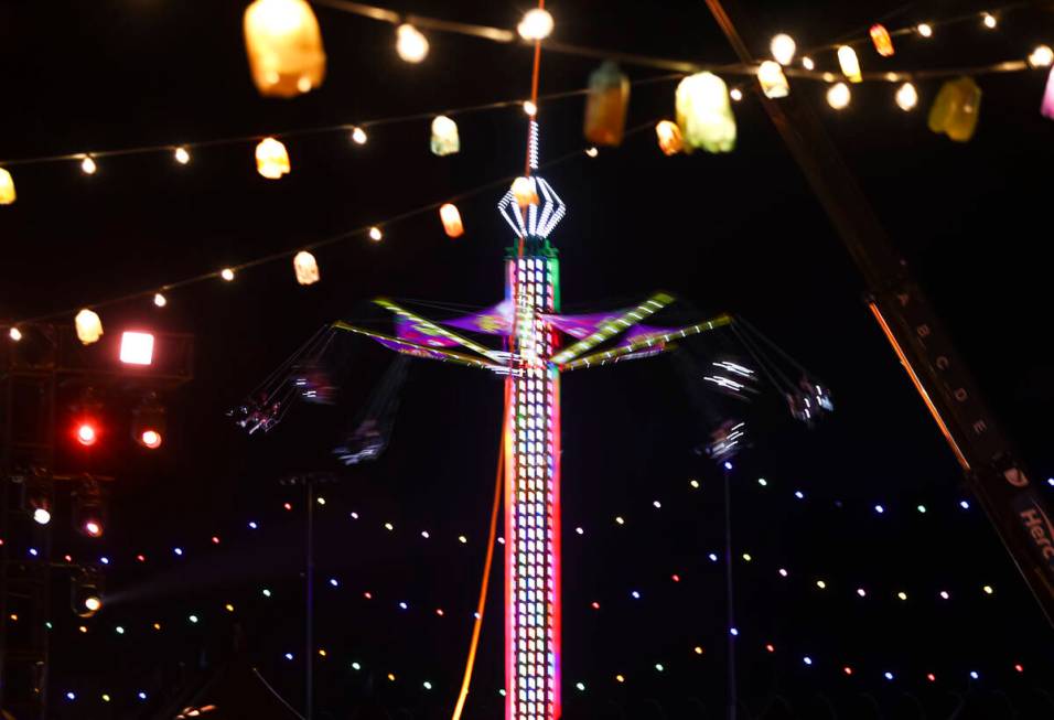 A carnival ride is pictured through various lights during the second day of the Electric Daisy ...