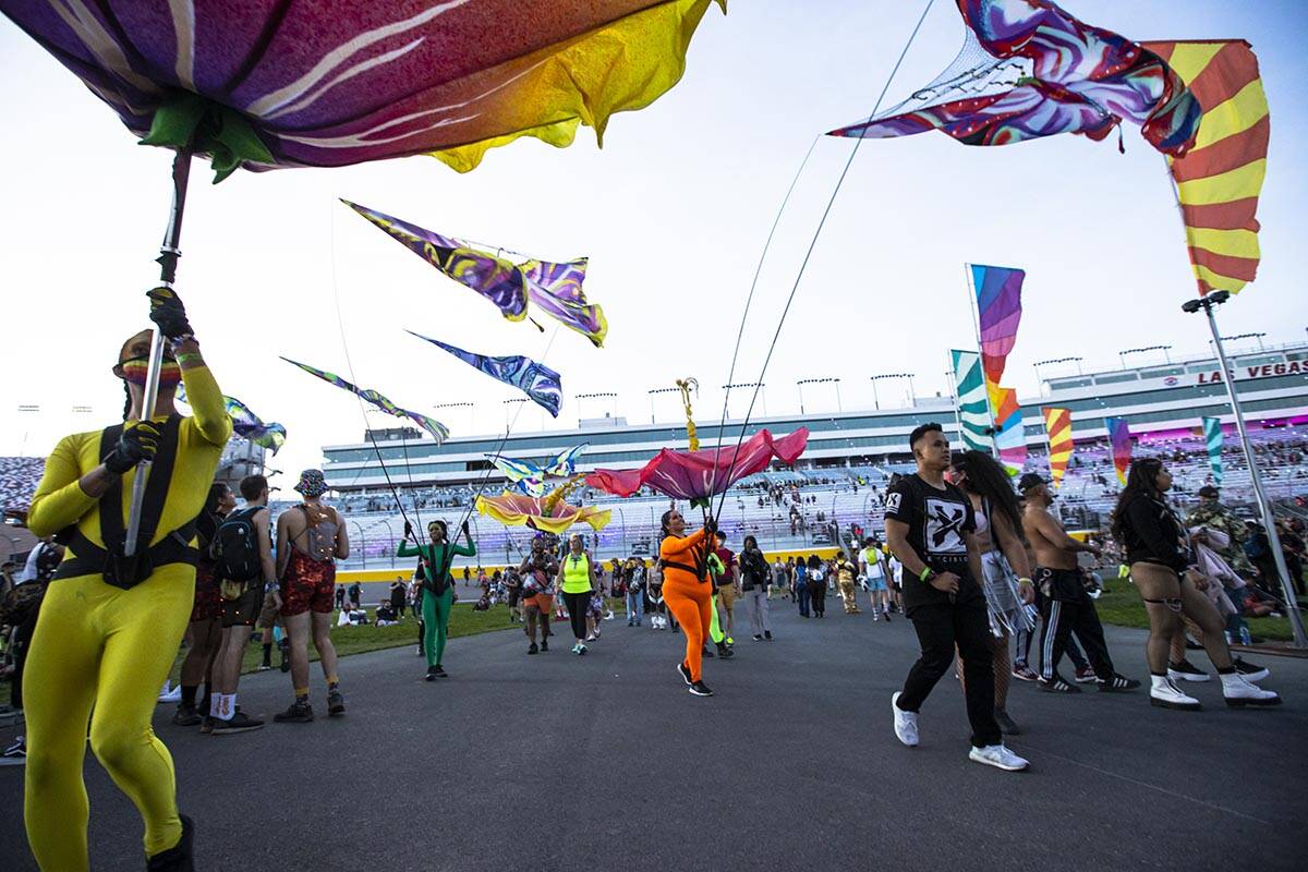 Costumed performers entertain the crowd as attendees arrive at the Cosmic Meadow stage during t ...