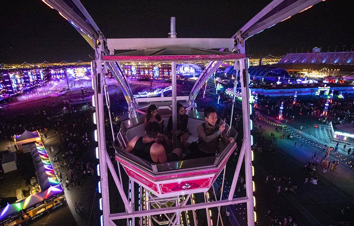 Attendees take in the sights from a ferris wheel during the first day of the Electric Daisy Car ...