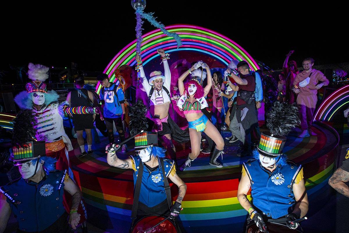 Costumed performers dance and take pictures with attendees during the first day of the Electric ...