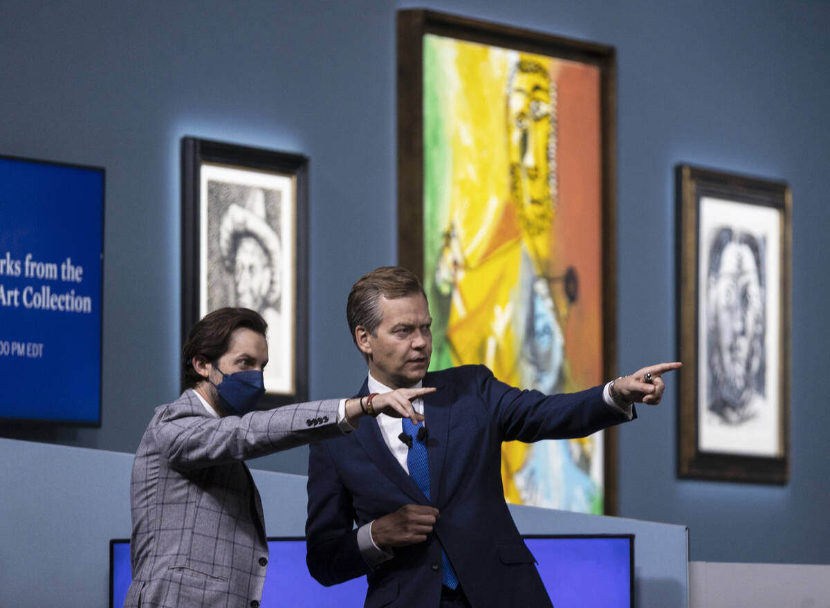 Oliver Barker, right, gets ready to begin an auction held by Sotheby's featuring eleven of Pabl ...
