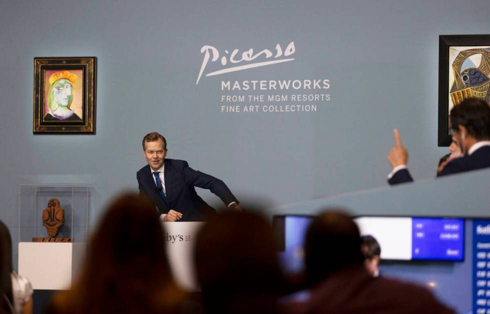 Oliver Barker, left, takes bids during an auction held by Sotheby's featuring eleven of Pablo P ...