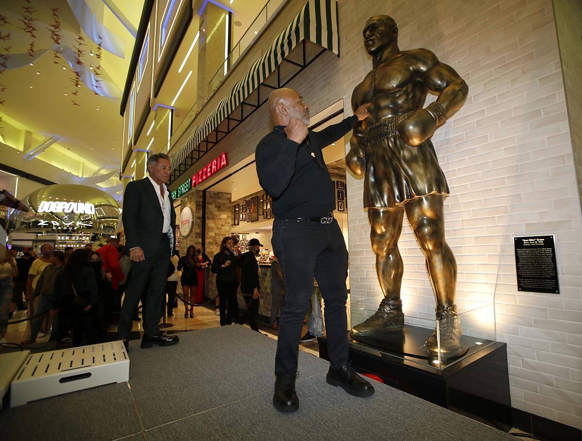 Former boxer Mike Tyson, center, poses for photos in front of newly unveiled Tyson's stature at ...