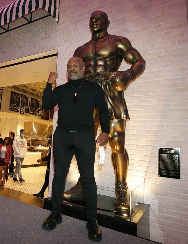 El ex boxeador Mike Tyson, en el centro, posa para fotos frente a la recién inaugurada estatua ...