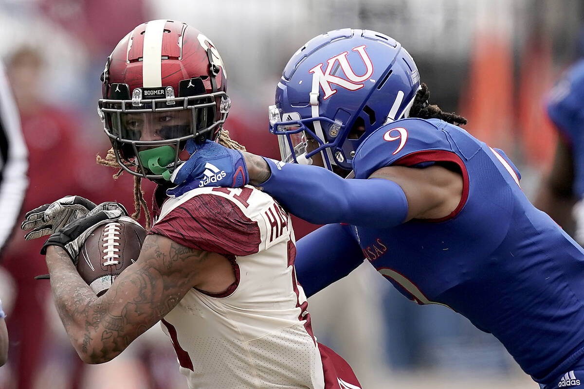 Oklahoma wide receiver Jadon Haselwood is tackled by Kansas cornerback Jeremy Webb (9) during t ...