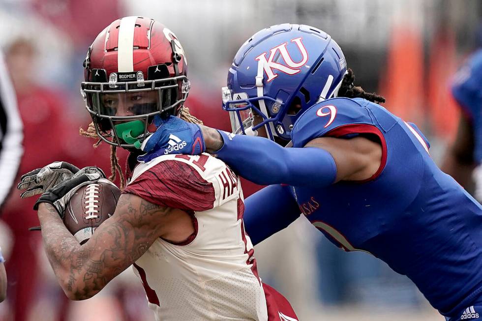 Oklahoma wide receiver Jadon Haselwood is tackled by Kansas cornerback Jeremy Webb (9) during t ...