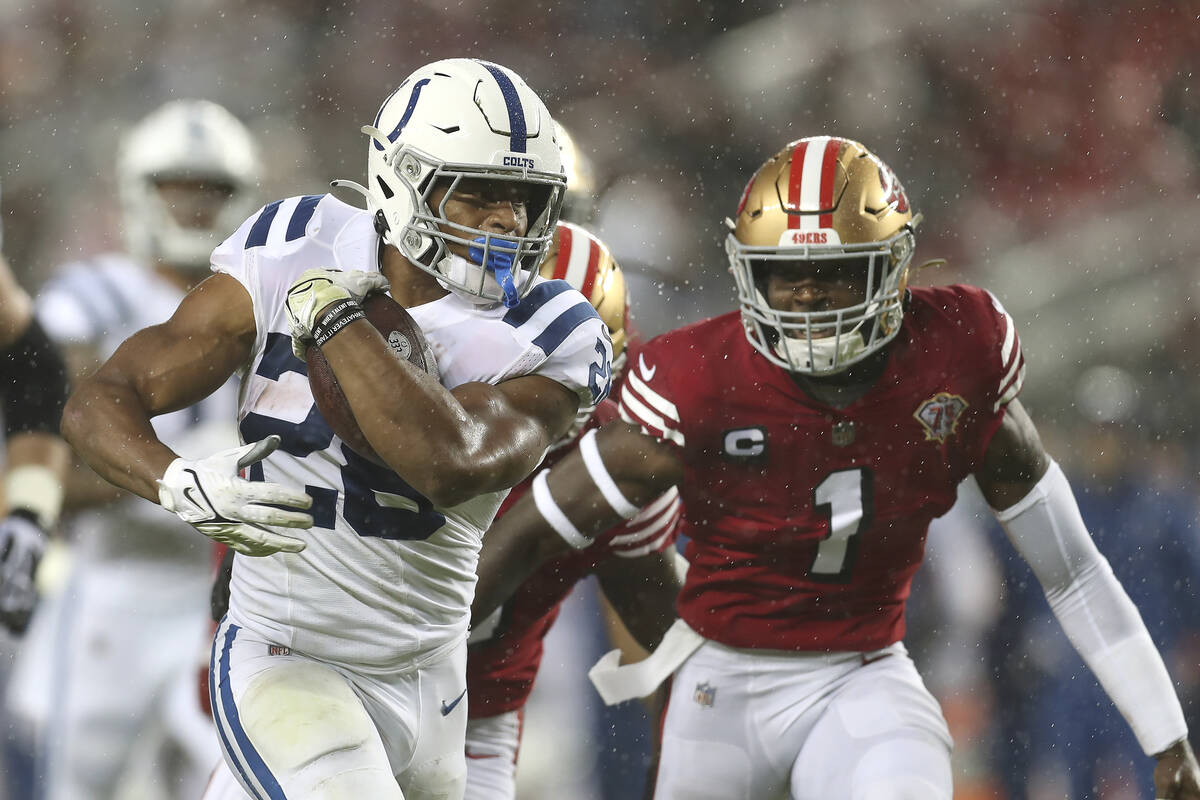 Indianapolis Colts running back Jonathan Taylor, left, runs in front of San Francisco 49ers fre ...