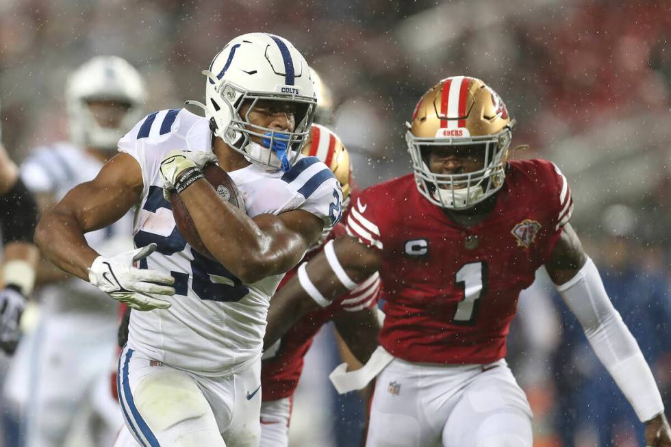 Indianapolis Colts running back Jonathan Taylor, left, runs in front of San Francisco 49ers fre ...