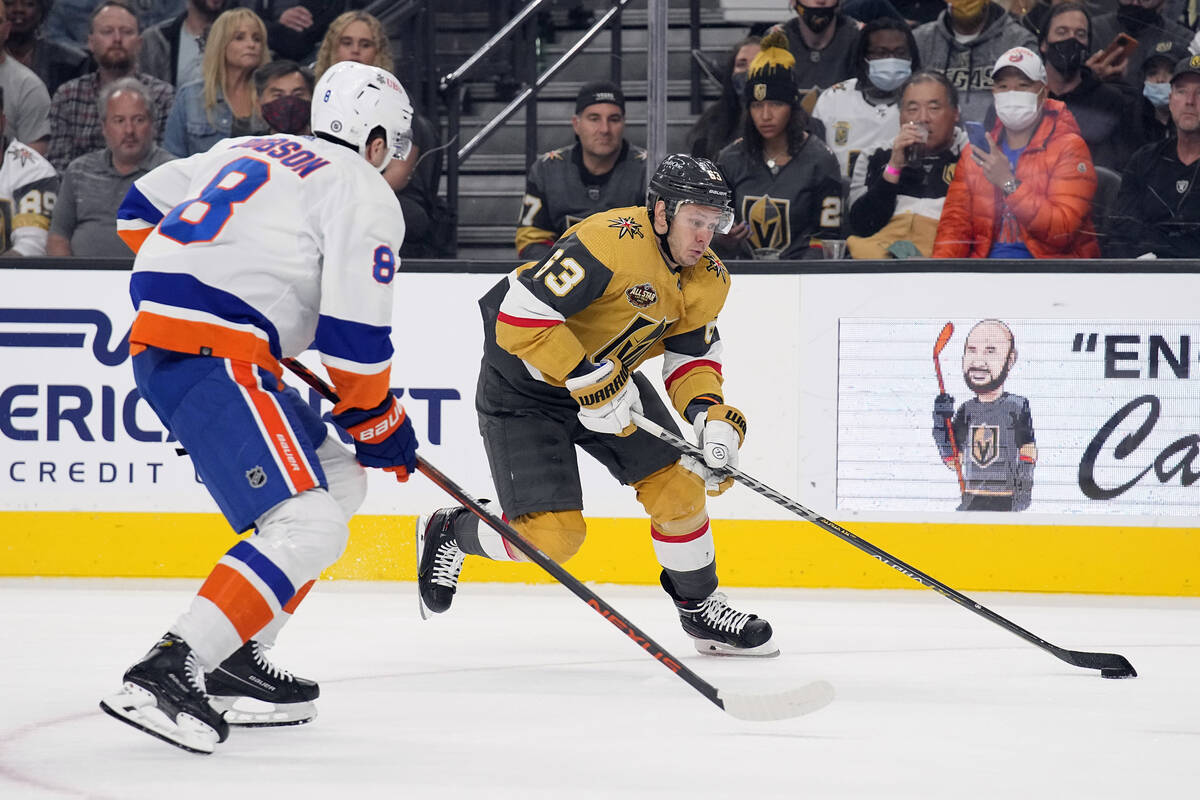 Vegas Golden Knights Evgenii Dadonov drives on New York Islanders defenseman Noah Dobson (8) du ...