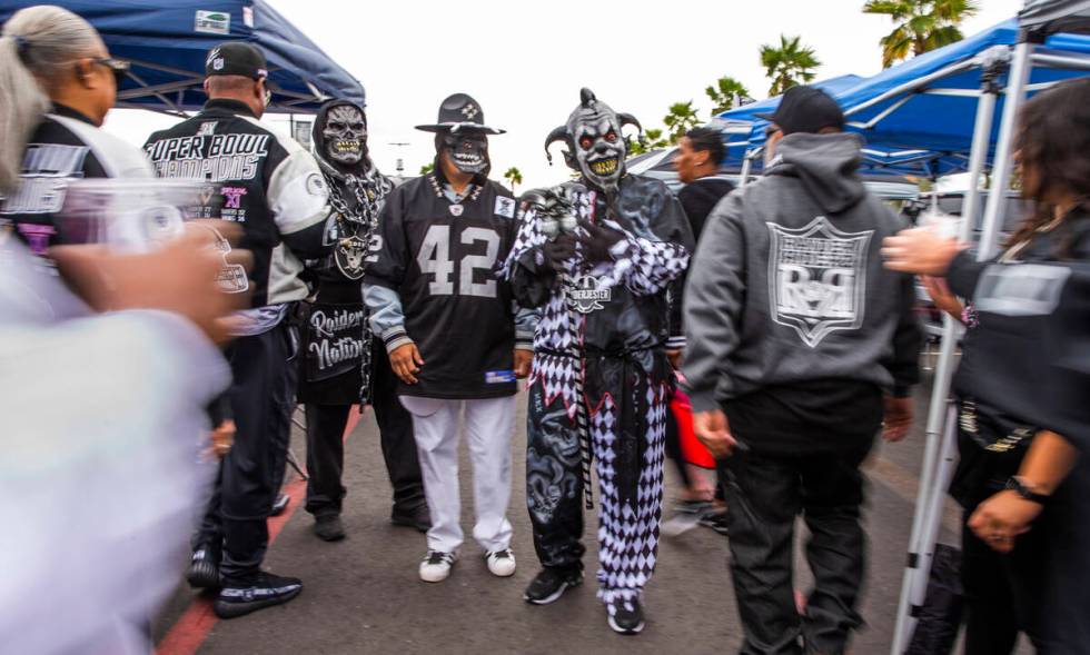 Raiders fans walk about tailgating before the first half of an NFL game at Allegiant Stadium on ...