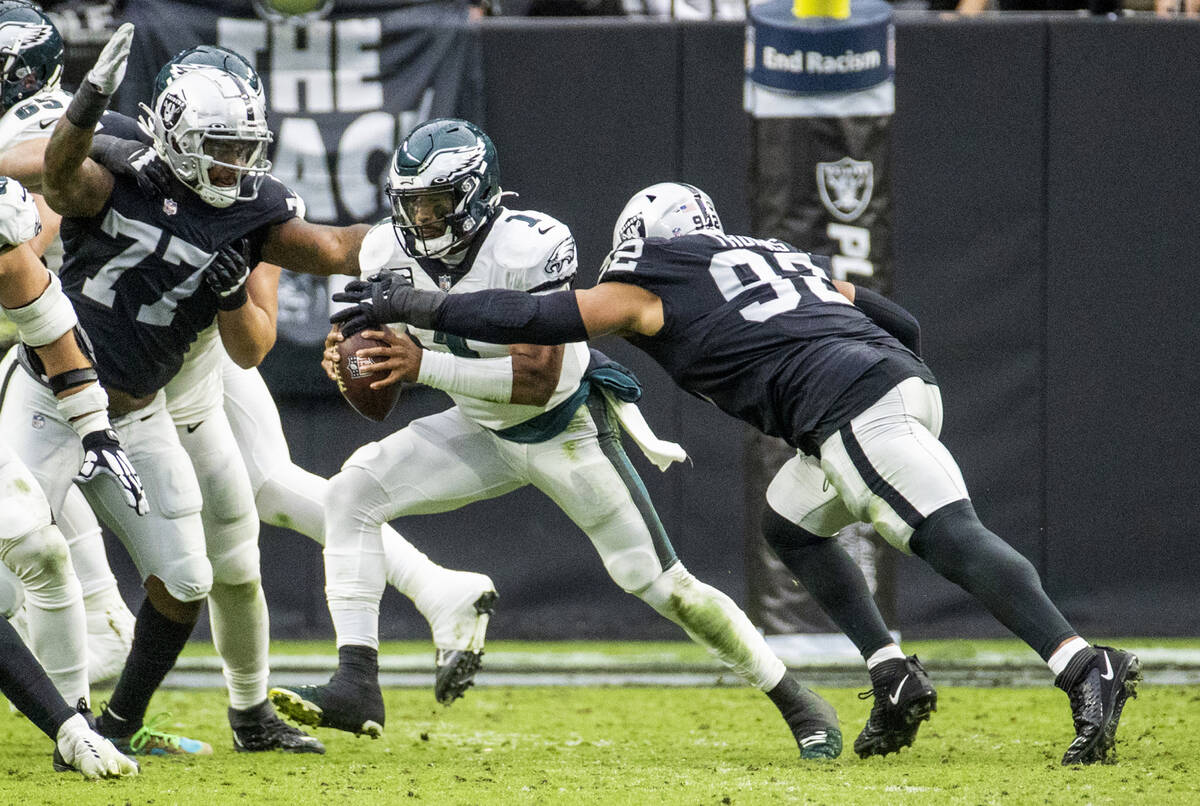 Philadelphia Eagles quarterback Jalen Hurts (1) gets a hand on the ball from Raiders defensive ...