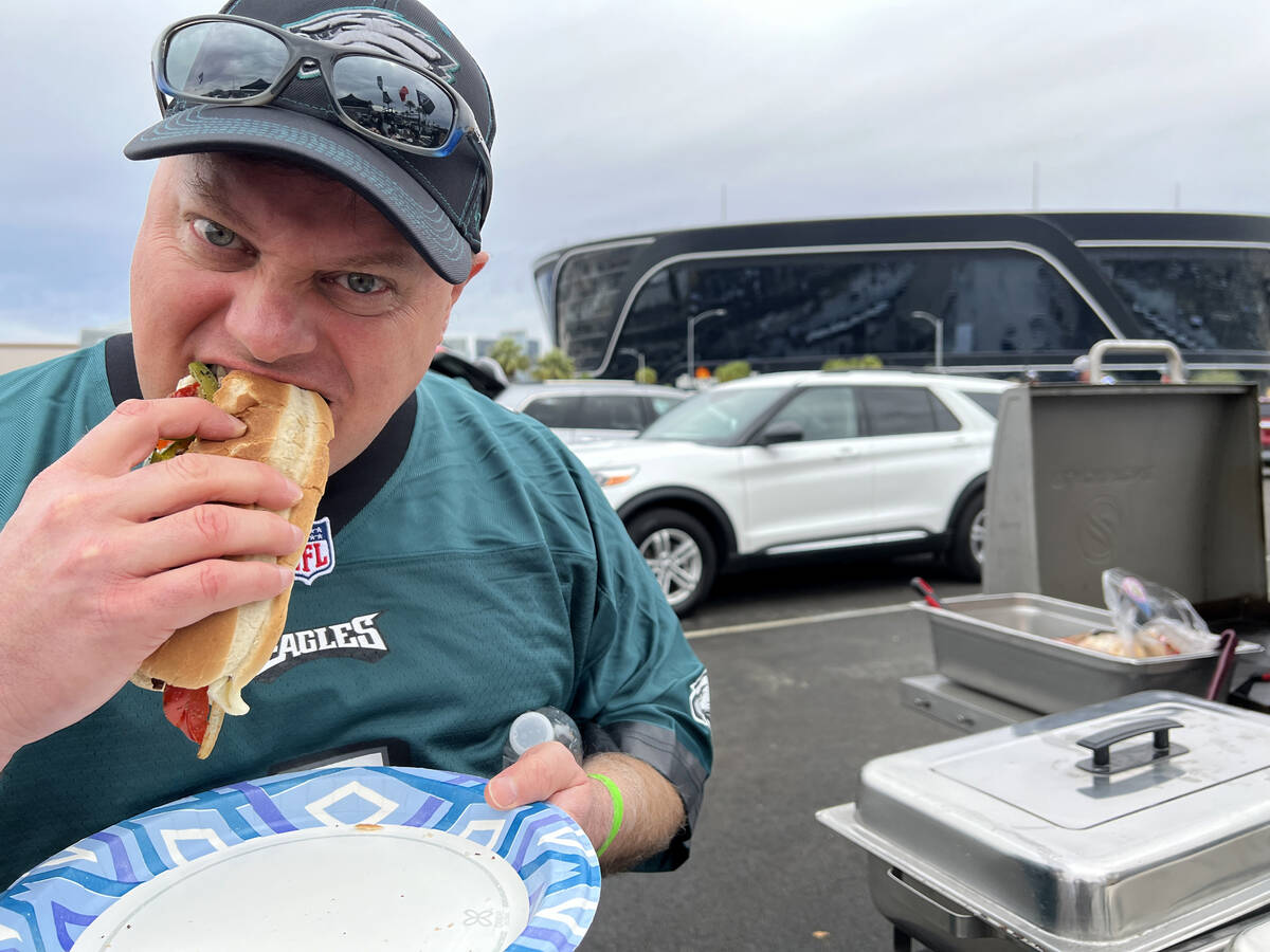 Aaron Starr of Philadelphia eats a Philadelphia cheesesteak while tailgating before the Raiders ...