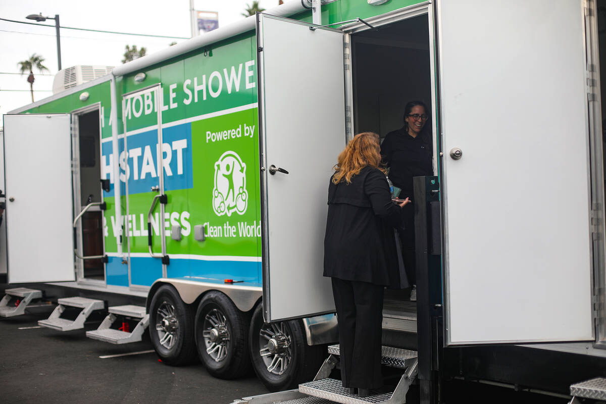 Guests check out the new mobile shower unit made through the partnership of Clean the World and ...