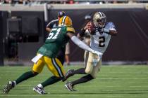 New Orleans Saints quarterback Jameis Winston (2) rolls out to pass while being defended by Gre ...