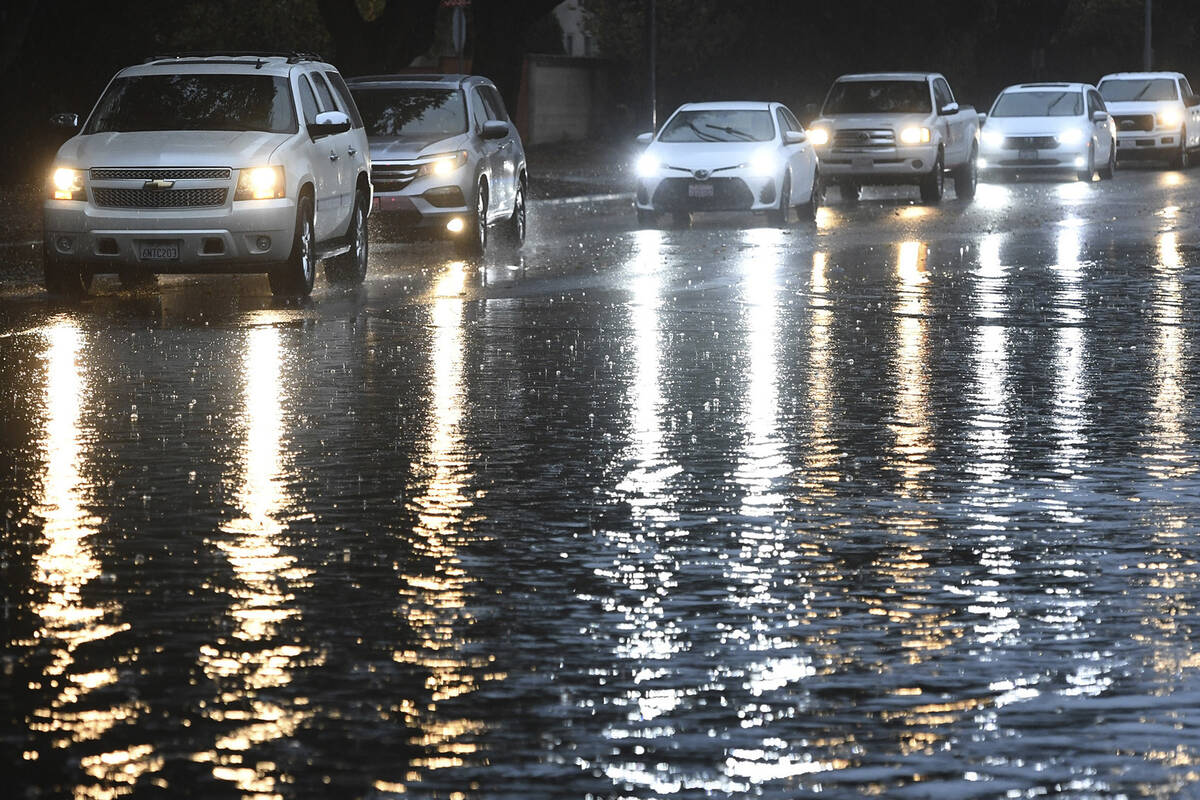 Commuters cautiously drive around a flooded section of Peach Avenue on Monday, Oct. 25, 2021, i ...