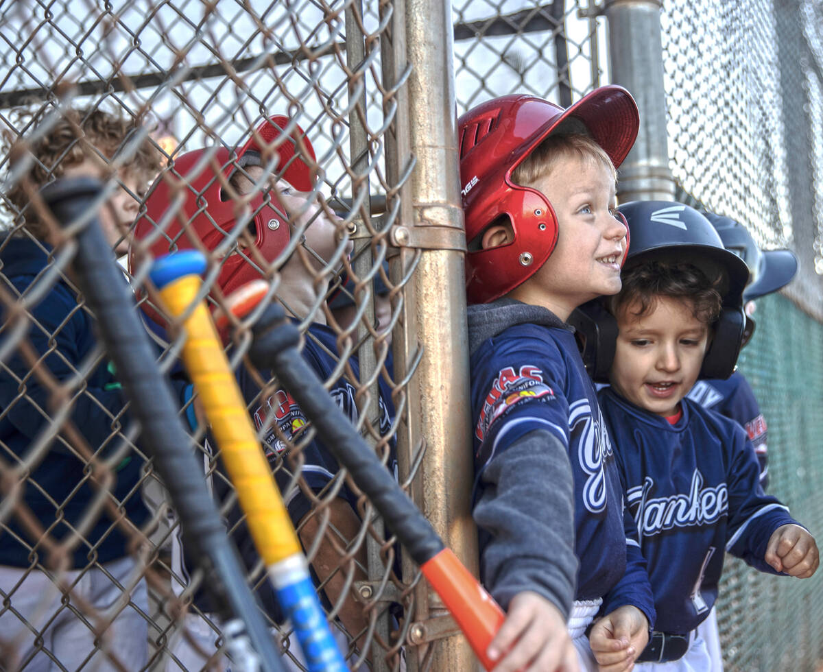 Yankees players Payton Akin, middle, and Gunnar Cross wait for their turn to bat during a tee b ...