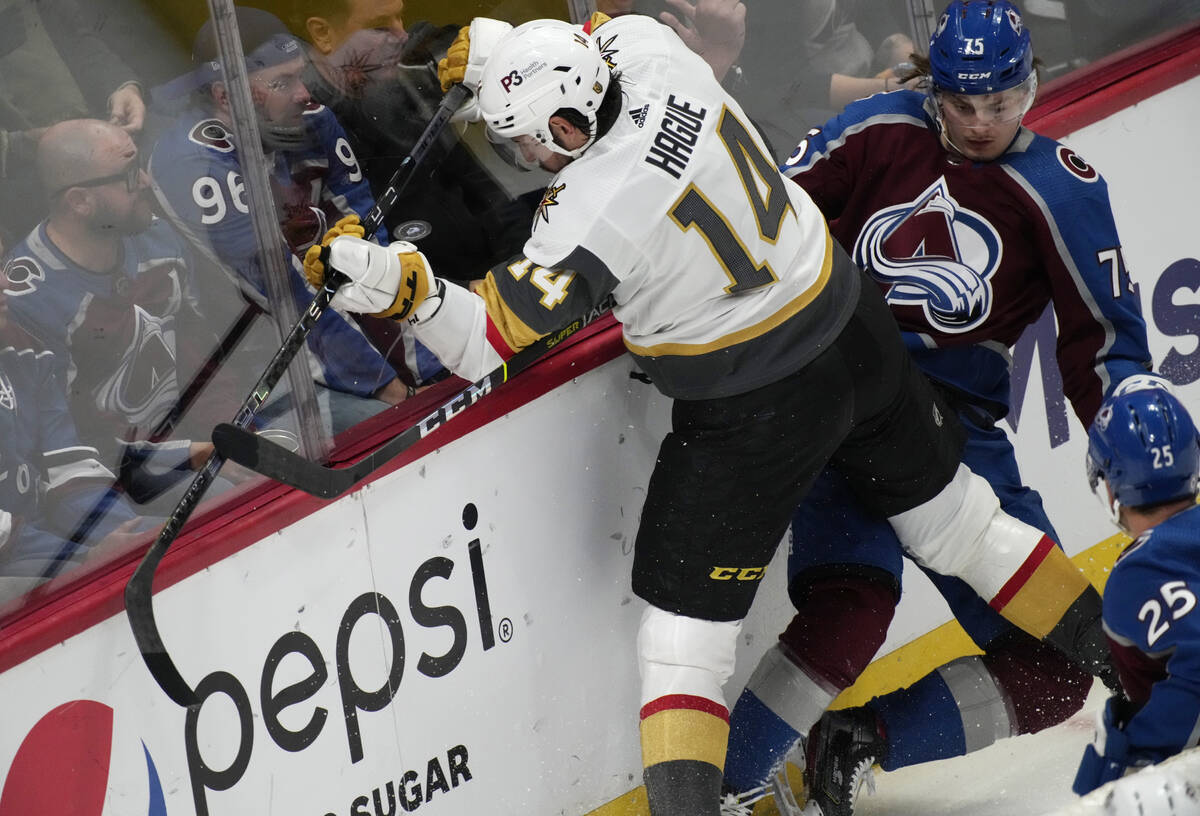 Vegas Golden Knights defenseman Nicolas Hague, left, fights for control of the puck with Colora ...