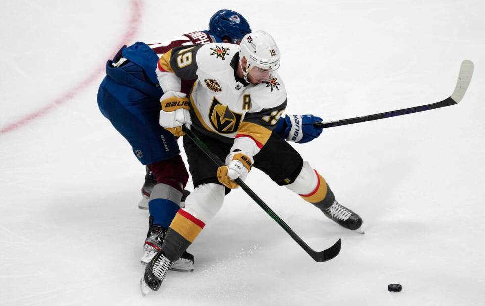 Vegas Golden Knights right wing Reilly Smith, front, is tied up by Colorado Avalanche left wing ...