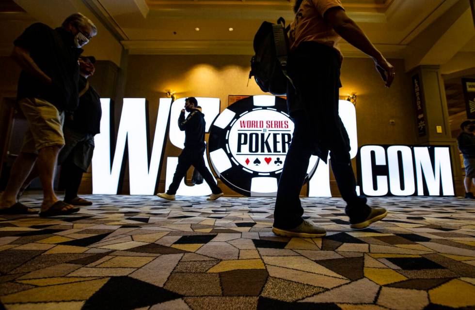People walk by signage for the World Series of Poker at the Rio in Las Vegas on Thursday, Oct. ...
