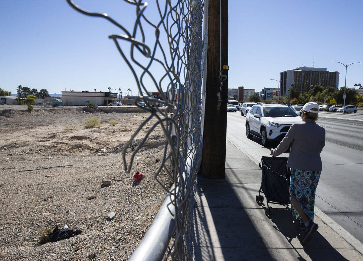 A pedestrian walks past a plot of land, left, near UNLV, on Wednesday, Oct. 27, 2021, in Las Ve ...