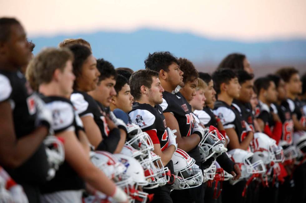Liberty High School's players line up for the national anthem before a football game against Le ...