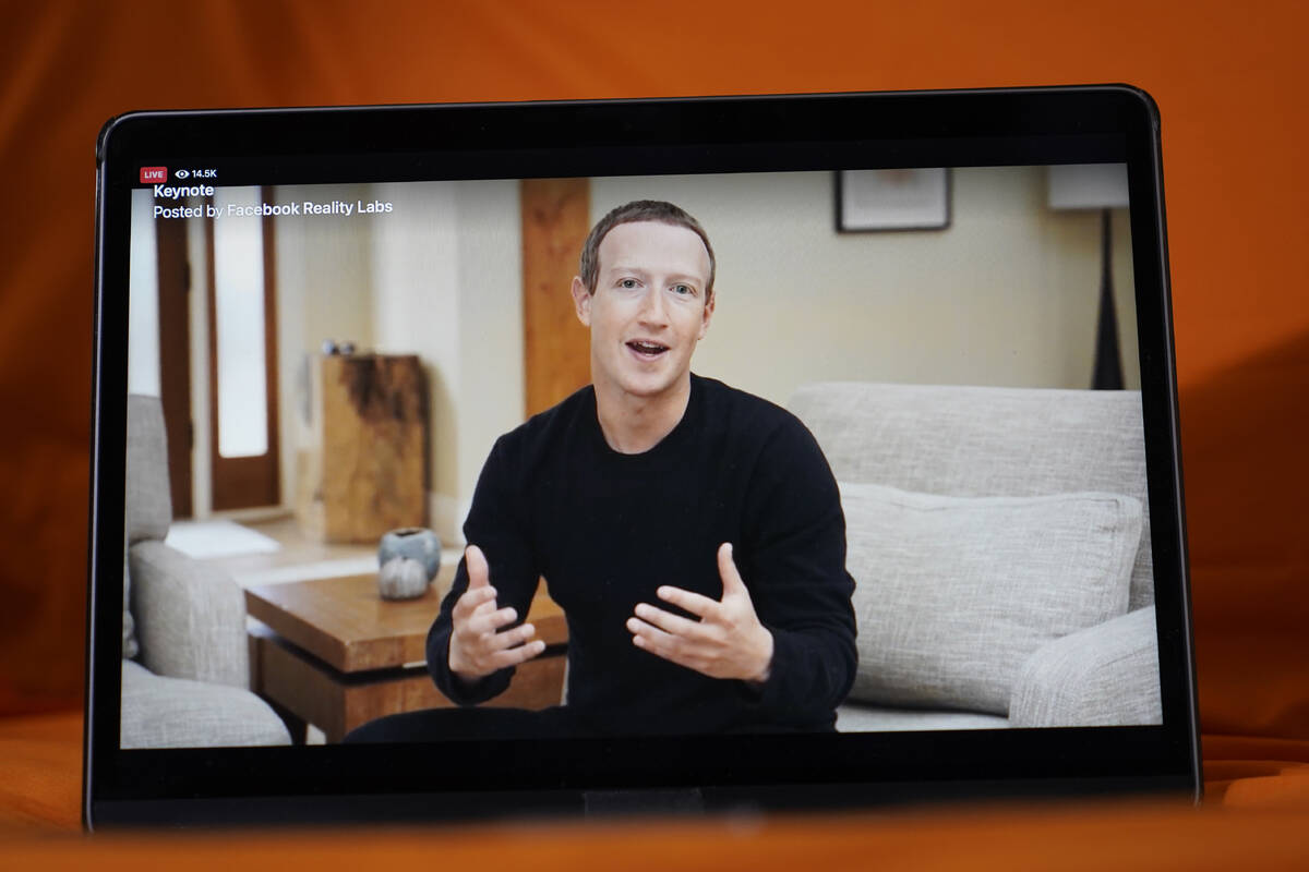 Seen on the screen of a device in Sausalito, Calif., Facebook CEO Mark Zuckerberg delivers the ...