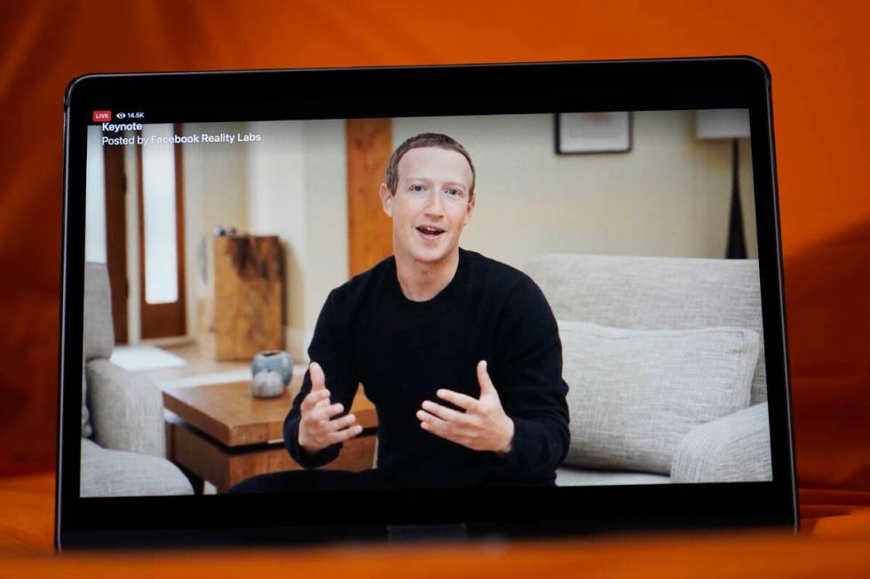 Seen on the screen of a device in Sausalito, Calif., Facebook CEO Mark Zuckerberg delivers the ...