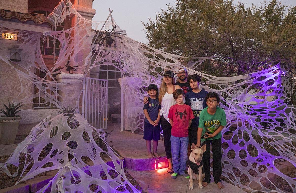 Tiffany and Leroy Garcia with their four sons in front of their Disney-inspired Halloween home, ...