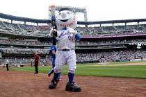 Mr Met distributes t-shirts to fans during the sixth inning of a game against the Milwaukee Bre ...