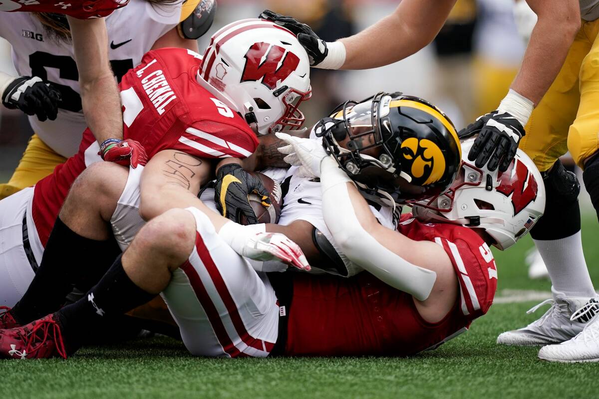 Wisconsin's linebackers Leo Chenal (5) and Jack Sanborn (57) stop Iowa wide receiver Tyrone Tra ...
