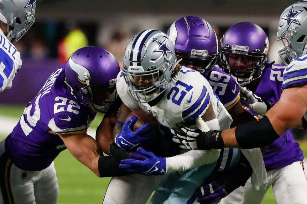 Dallas Cowboys running back Ezekiel Elliott (21) is tackled by Minnesota Vikings safety Harriso ...