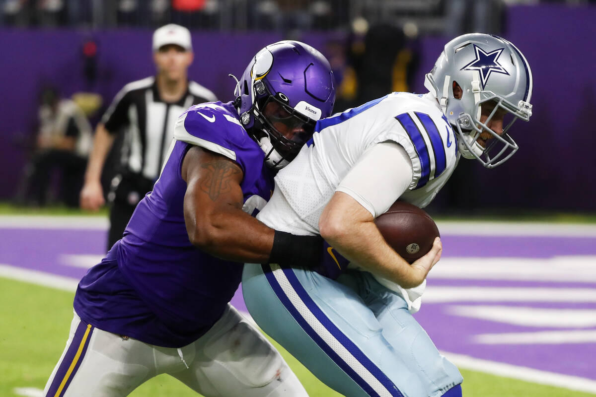 Dallas Cowboys quarterback Cooper Rush (10) is sacked by Minnesota Vikings defensive end Everso ...