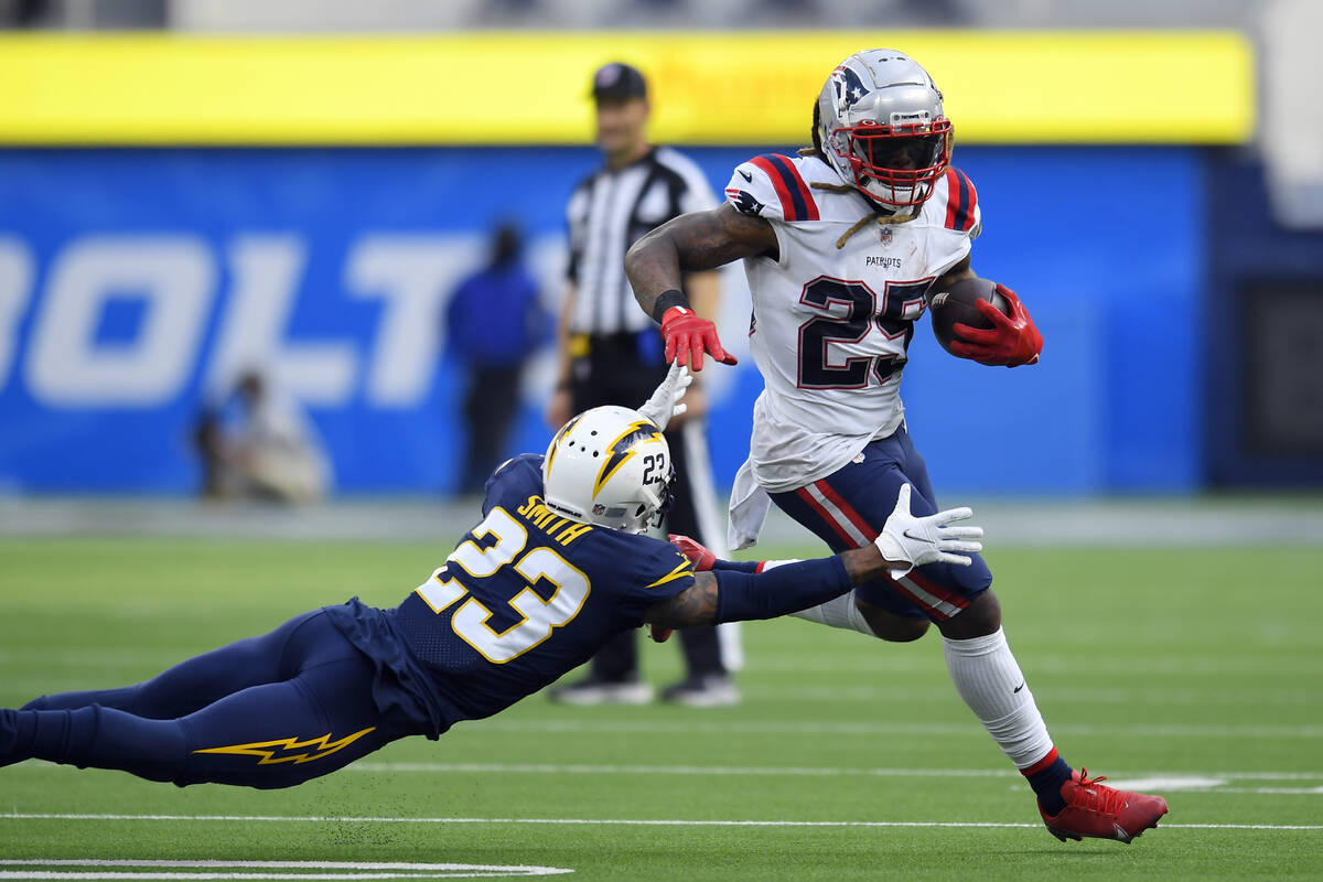 New England Patriots running back Brandon Bolden (25) goes around the tackle attempt from Los A ...