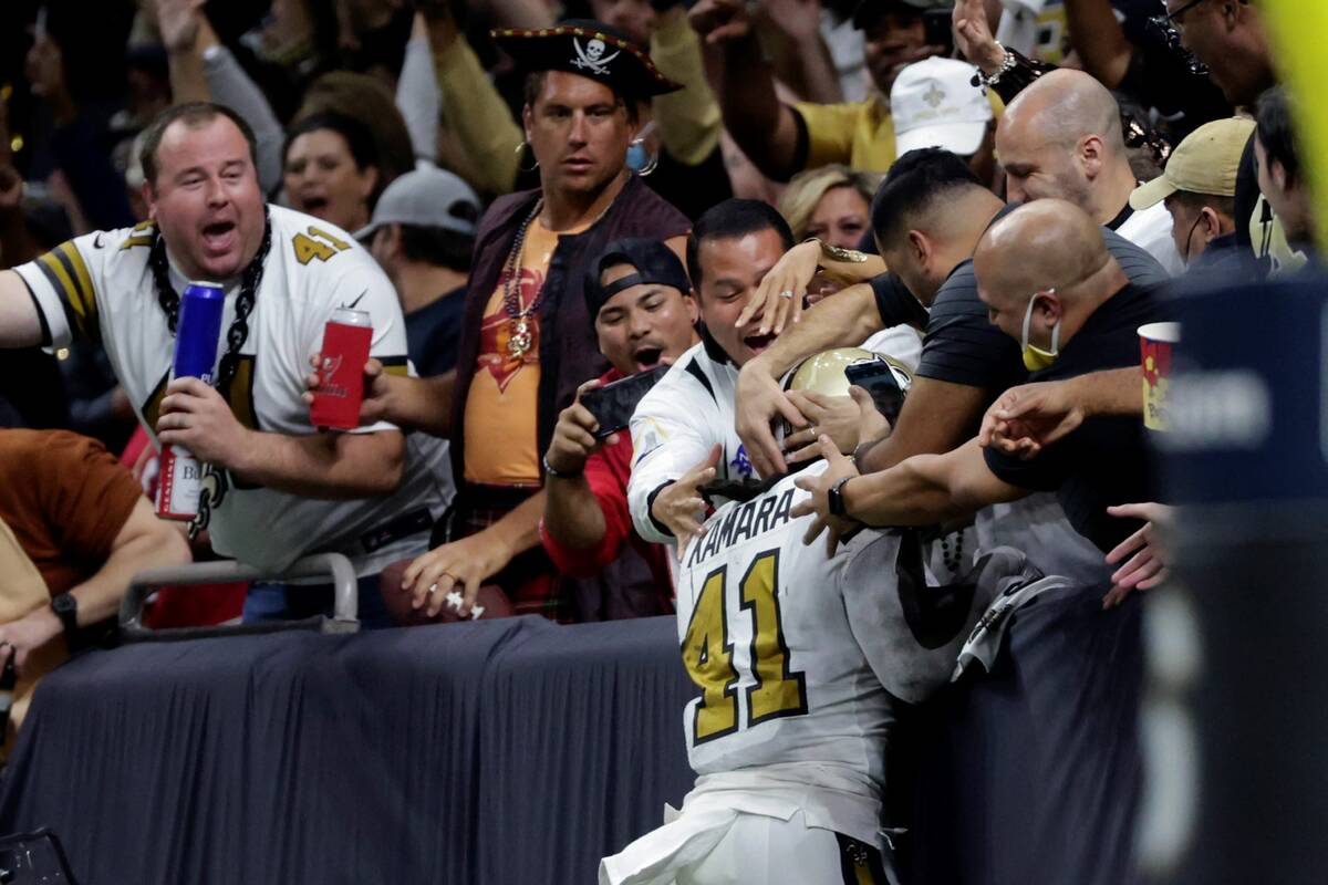 Fans cheer as New Orleans Saints running back Alvin Kamara (41) leaps towards the stands after ...