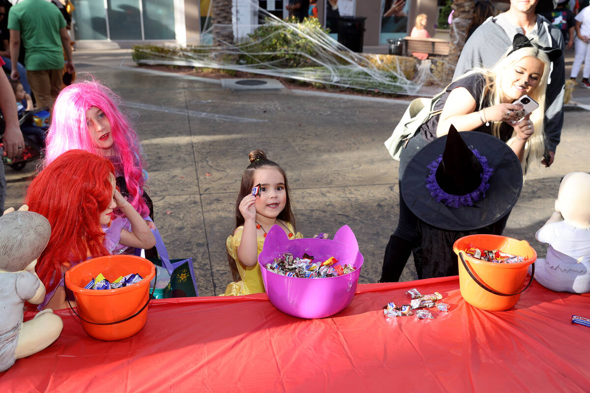 Everly Accordino, 5, of Henderson, center, grabs some candy from the Life Realty booth during t ...
