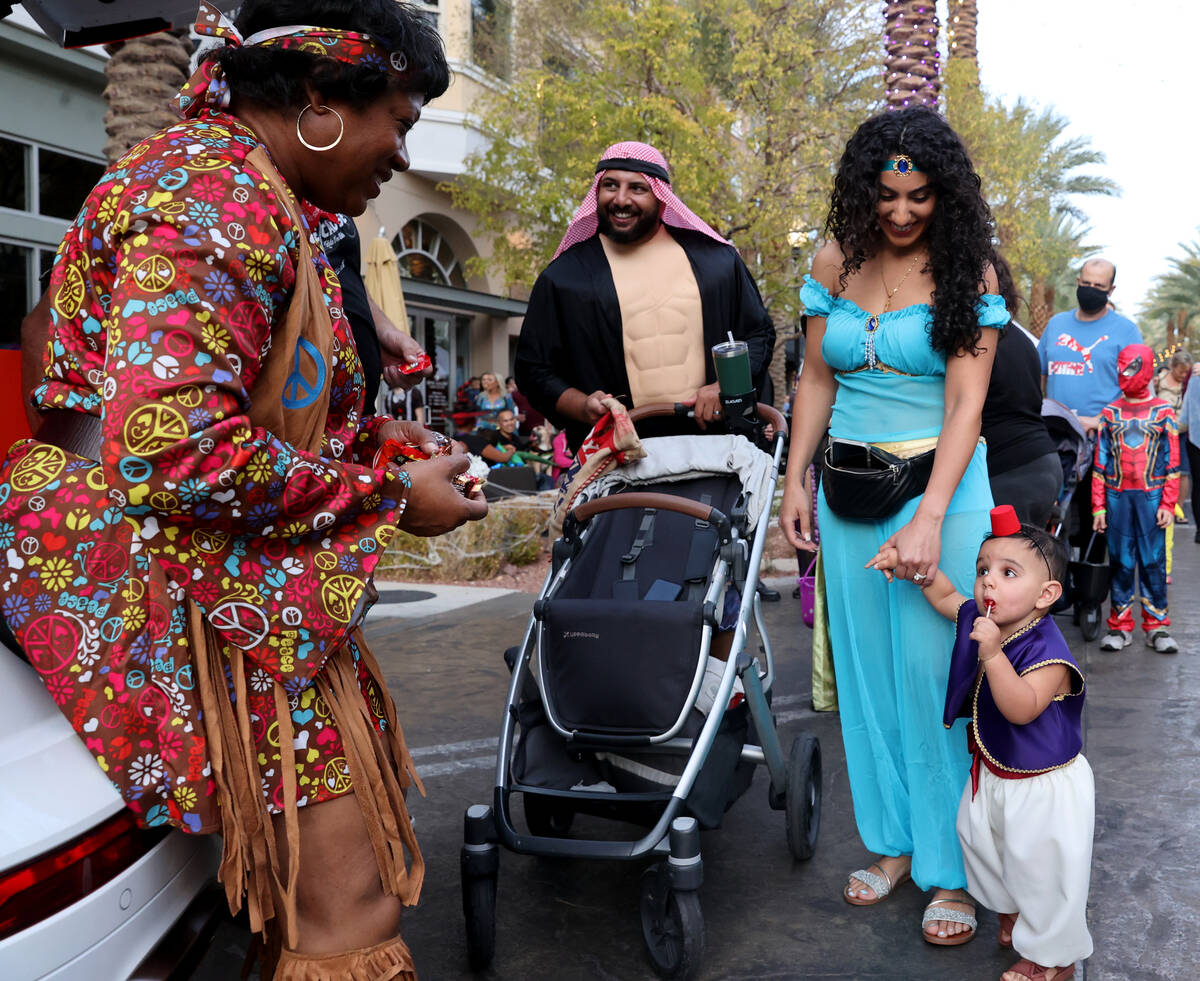 Fady Botros of Henderson, his wife Sally and son Stefanos, 14 months, get candy from Venus Hamm ...